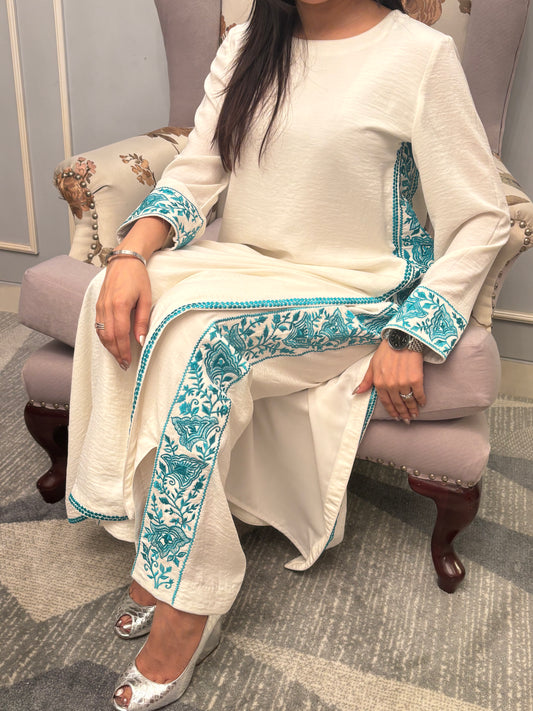 Grace finds its purest form in this ivory kurti set — where every drape whispers luxury and every thread is an ode to femininity. Crafted for evenings that linger and moments that matter, this ensemble pairs timeless charm with modern detail. From the fluid fall of the fabric to the delicate play of textures, this is not just attire — it’s presence, poised.