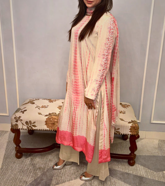 This elegant three-piece ensemble showcases a unique tie-dye pattern in soft cream and delicate rose hues with hand &amp; neck handwork (zardousi work), creating a graceful and contemporary look. Intricate floral embroidery adorns the sleeves and extends to the back of the kurti, adding a touch of traditional artistry and refined detail. Delicate button accents further enhance its sophisticated charm.

Paired with comfortable bottoms and a matching dupatta, this set is perfect for celebrating special times