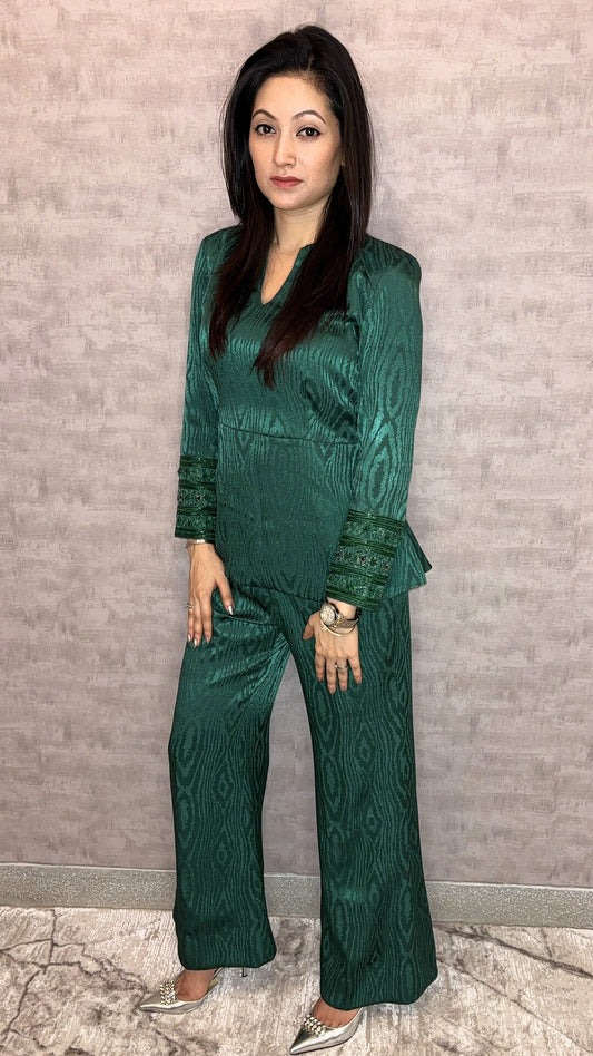 Presenting the Emerald Jewel Co-ord Set, a luxurious highlight from Taraashi's Platinum Collection. This stunning set features a rich, textured fabric in deep emerald green that glows with subtle sheen. The elegantly structured top pairs with flowing trousers, while intricately embellished cuffs add a captivating sparkle. Embrace sophisticated glamour and the premium artistry unique to Taraashi Platinum.