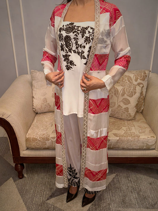Whispers of tradition, spun in threads of ivory and ebony, kissed with a vibrant blush. This Taraashi three-piece set drapes with an effortless elegance, where intricate floral embroidery artistry meets a intricate handwork (zardousi work). It's an ode to understated sophistication, designed for the woman who carries grace in every gesture.

From the delicate embroidery that tells a story to the fluid lines that embrace the form, this is more than an outfit – it's a quiet statement of refined femininity.